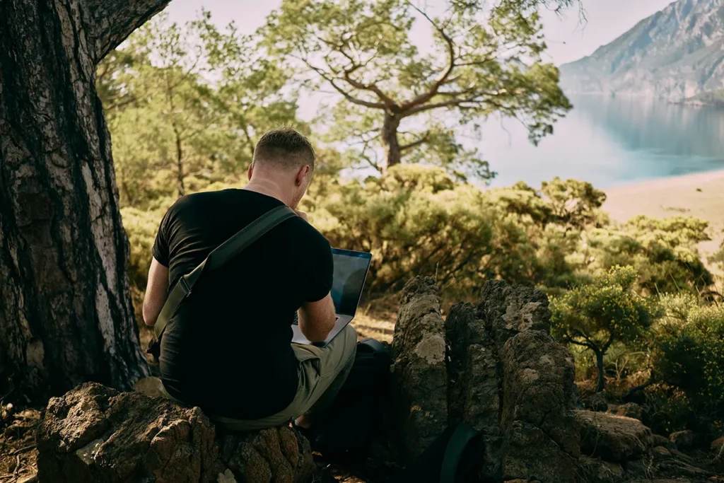 man working on laptop in nature-unsplash